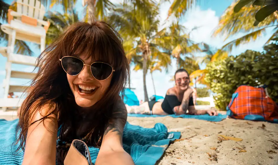 Happy couple enjoying a beach vacation under palm trees